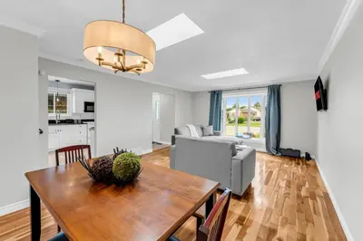 a living room with a table and a couch at Bright 6BR Near Niagara Falls with BBQ Yard in Thorold