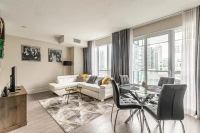 a living room with a white couch and a glass table at Modern 1 Bedroom Condo Front Street Downtown Toronto in Toronto