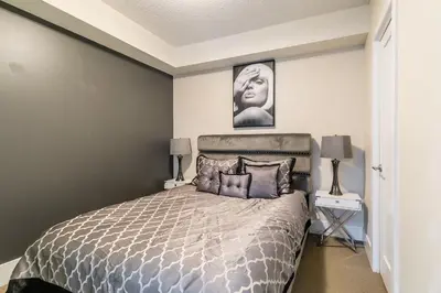 a bedroom with a bed and a picture on the wall at Modern 1 Bedroom Condo Front Street Downtown Toronto in Toronto
