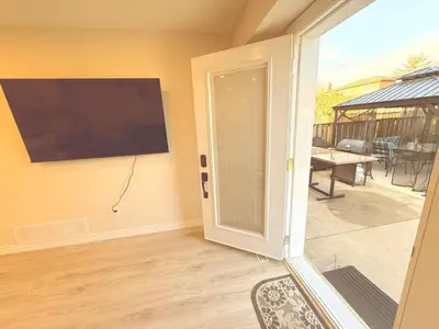 a living room with a sliding glass door and a television at Modern 1-BR Suite EV Charger, Backyard BBQ & Near Square One in Mississauga