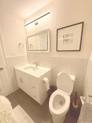 a bathroom with a toilet and a sink and a mirror at Modern 1-BR Suite EV Charger, Backyard BBQ & Near Square One in Mississauga
