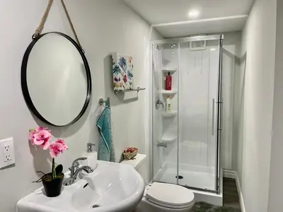 a white bathroom with a sink and a shower at Master bedroom in Mississauga