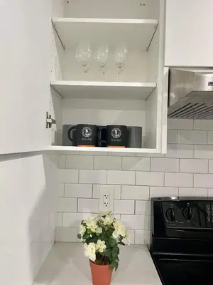 a kitchen with two wine glasses and a vase with flowers at Master bedroom in Mississauga
