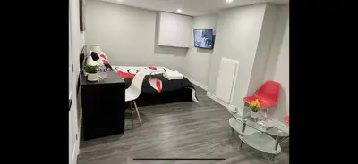 a room with a bed and a desk and a red chair at Master bedroom in Mississauga