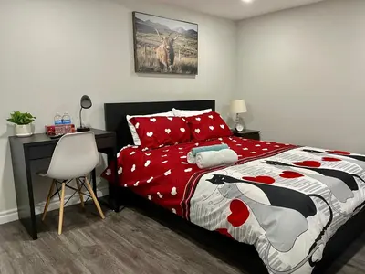 a bedroom with a bed with a red and white comforter at Master bedroom in Mississauga