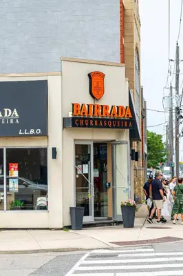 a store on a street with people walking in front of it at Spacious 3-Bedroom SkyLoft with Beautiful City Views and Parking in Toronto