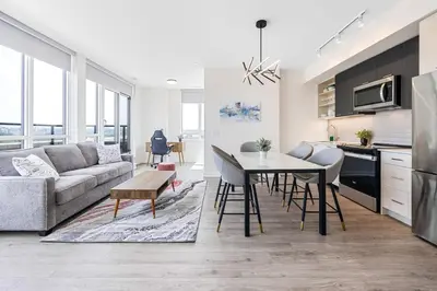 a kitchen and living room with a couch and a table at Spacious 3-Bedroom SkyLoft with Beautiful City Views and Parking in Toronto