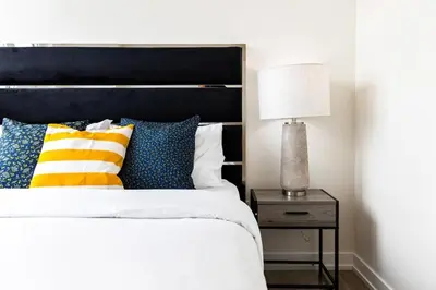 a bed with colorful pillows and a lamp on a night stand at Spacious 3-Bedroom SkyLoft with Beautiful City Views and Parking in Toronto