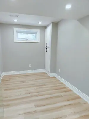 a living room with white walls and wood floors at 5 Bed 4Bath 9 Parking Lakeside Retreat in Ajax