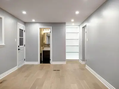 an empty hallway with white walls and wooden floors at 5 Bed 4Bath 9 Parking Lakeside Retreat in Ajax