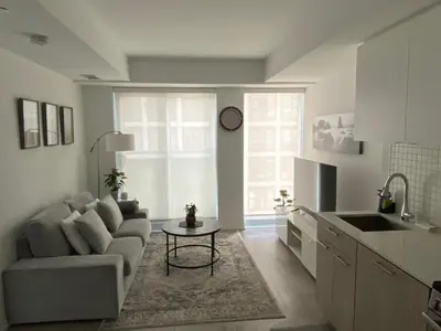 a living room with a couch and a table at Luxury All-Inclusive One-Bedroom Condo in Downtown in Toronto