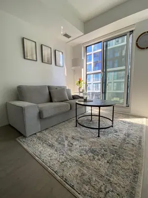 a living room with a couch and a table at Luxury All-Inclusive One-Bedroom Condo in Downtown in Toronto