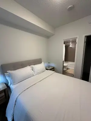 a bedroom with a large white bed with white pillows at Cozy Condo Midtown Toronto in Toronto