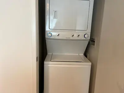 a washer and dryer sitting on top of a refrigerator at Cozy Condo Midtown Toronto in Toronto