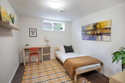 a bedroom with a bed and a desk and a chair at East Toronto BNB in Toronto