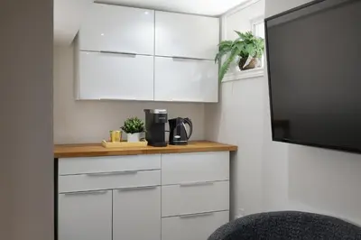 a kitchen with white cabinets and a tv at East Toronto BNB in Toronto