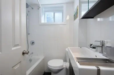 a white bathroom with a sink and a toilet at East Toronto BNB in Toronto