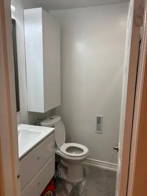 a white bathroom with a toilet and a sink at Home in Scarborough, near GO station, TTC and UoT in Toronto