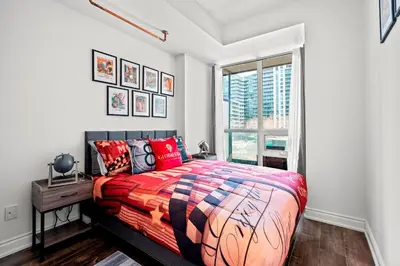 a bedroom with a large bed and a window at 1 Bedroom Condo with Balcony Fort York Downtown Toronto in Toronto