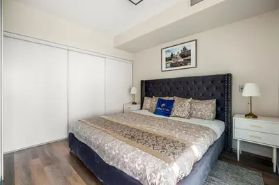 a bedroom with a large bed with a black headboard at High Floor 1 Bedroom plus Den Condo Apartment City View North York Toronto in Toronto