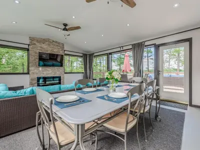 a dining room with a table and chairs and a couch at Private Lakefront Cottage Living on Muldrew Lake in Gravenhurst