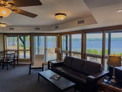 a living room with a couch and a view of the water at Private Lakefront Cottage Living on Muldrew Lake in Gravenhurst