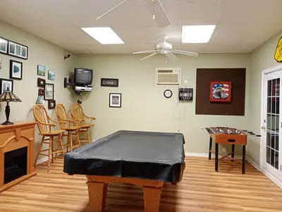 a living room with a ping pong table and chairs at Lakeside Villa across Whisky Run Golf Club in Port Colborne