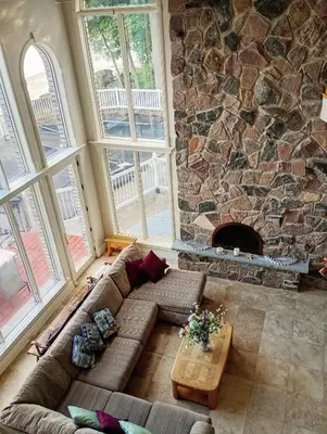 a living room with a couch and a stone fireplace at Lakeside Villa across Whisky Run Golf Club in Port Colborne