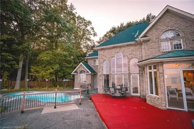 a house with a red rug next to a swimming pool at Lakeside Villa across Whisky Run Golf Club in Port Colborne