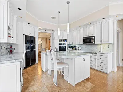 a large kitchen with white cabinets and a large island at Lakeside Villa across Whisky Run Golf Club in Port Colborne