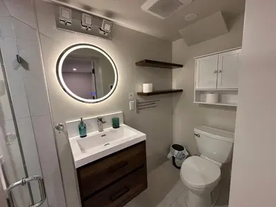 a bathroom with a toilet and a sink and a mirror at Spacious 2 Bedroom & 2 Bathroom Suit Near Fairview Mall & Waterloo Airport in Kitchener