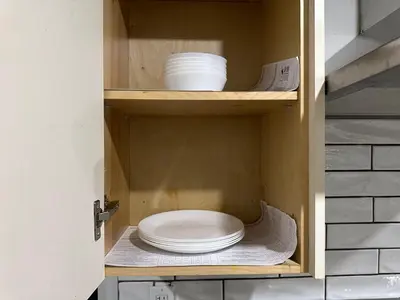 a cabinet with plates and bowls in it at Spacious 2 Bedroom & 2 Bathroom Suit Near Fairview Mall & Waterloo Airport in Kitchener