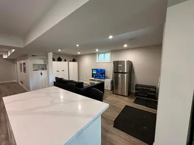 a kitchen and living room with a white counter top at Spacious 2 Bedroom & 2 Bathroom Suit Near Fairview Mall & Waterloo Airport in Kitchener