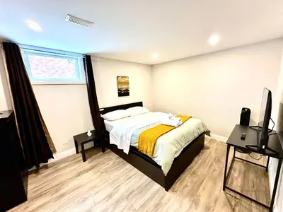 a bedroom with a bed and a flat screen tv at Spacious 2 Bedroom & 2 Bathroom Suit Near Fairview Mall & Waterloo Airport in Kitchener