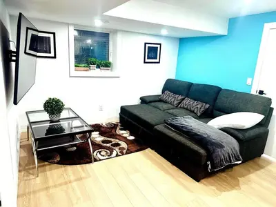a living room with a couch and a table at Modern 2BR suite Kitchen Workspace Laundry in London