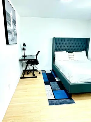 a bedroom with a bed and a desk with a keyboard at Modern 2BR suite Kitchen Workspace Laundry in London