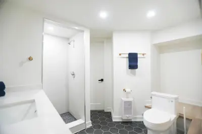 a white bathroom with a toilet and a shower at The Ember Suite in Peterborough