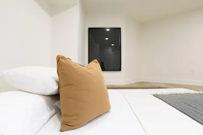 a bed with a pillow and a tv on the wall at The Ember Suite in Peterborough