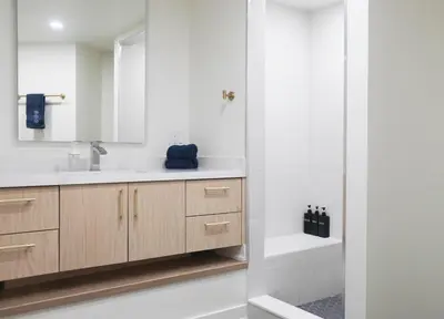 a bathroom with a sink and a mirror and a tub at The Ember Suite in Peterborough