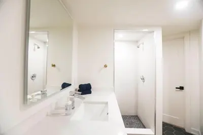 a white bathroom with two sinks and a mirror at The Ember Suite in Peterborough