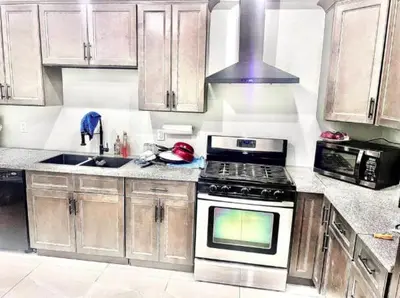 a kitchen with wooden cabinets and a stove top oven at Private Room In Cambridge B13 in Cambridge