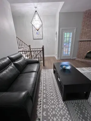 a living room with a leather couch and a coffee table at Beautiful Lake Side Neighbourhood Home in Ajax, ON in Ajax
