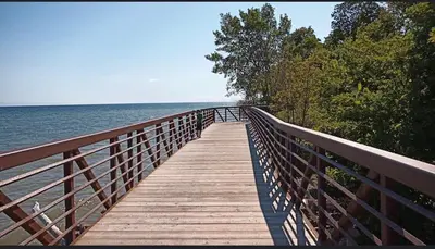 a wooden bridge over the water with a view of the ocean at Beautiful Lake Side Neighbourhood Home in Ajax, ON in Ajax