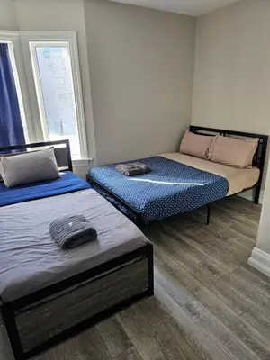 a room with two beds and a window at Toronto Holiday Home in Toronto