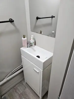 a white bathroom with a sink and a mirror at Toronto Holiday Home in Toronto