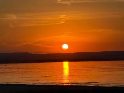 a sunset on the beach with the sun setting at Season Bliss - Blue Mountain Ski & Wasaga Beach in Wasaga Beach