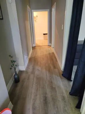 an empty hallway with wood floors in a house at Full Downtown Access-Central Location-Self Checkin in Toronto