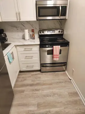 a kitchen with a stove and a microwave at Full Downtown Access-Central Location-Self Checkin in Toronto