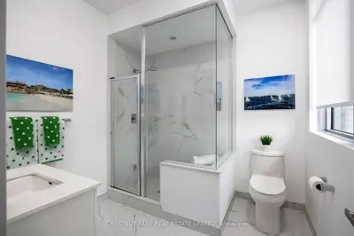 a white bathroom with a shower and a toilet at Waterfront Modern Vila in Innisfil