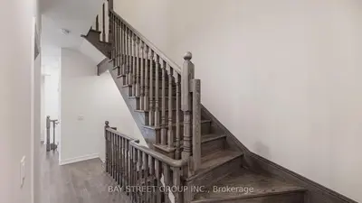 a wooden staircase in a room with a white wall at Modern in Richmond Hill in Richmond Hill